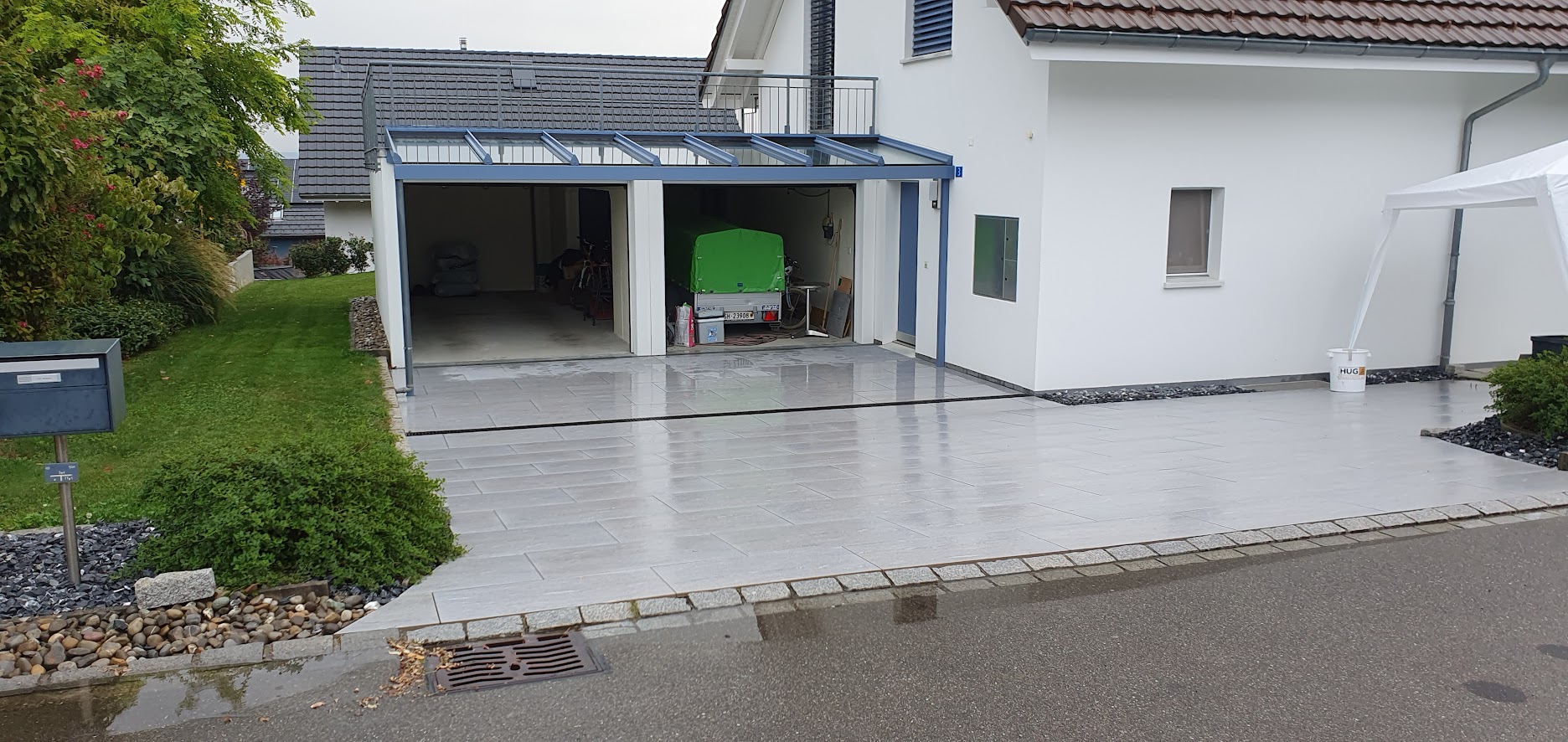 Heller Plattenbelag auf Terrasse und Einfahrt eines Einfamilienhauses