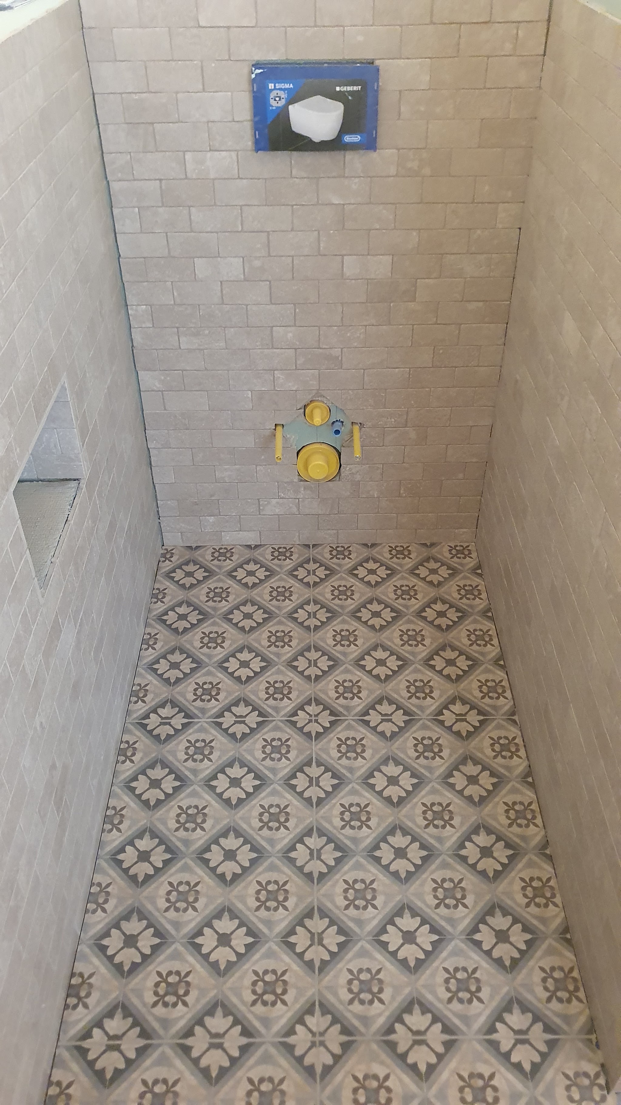 Dusche mit gemustertem Zementfliesen-Boden und hellen Wandplatten, verlegt von Steiner-Keramik